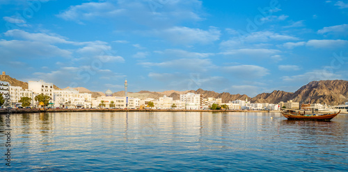Cuadro en lienzo Muscat Skyline with a traditional arabic Dhow anchored at the port
