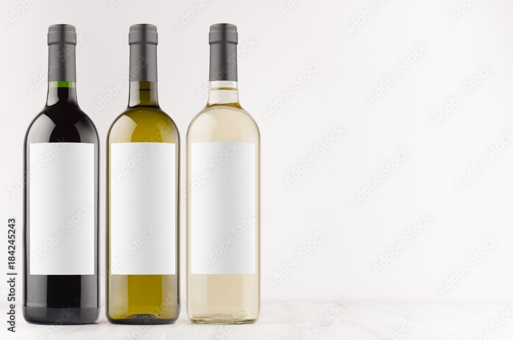 Wine bottles collection - transparent, green, black- with blank white labels on white wooden board, mock up, copy space. Template for advertising, design, branding identity. Wine bottles collection - transparent, green, black- with blank white labels on white wooden board, mock up, copy space. Template for advertising, design, branding identity.