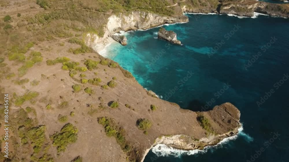Seascape, rocky coast, with wild beach, ocean, blue sea, waves, Nusa Penida, Indonesia. Aerial view Ocean with waves and rocky cliff. 4K video. Travel concept. Aerial footage Seascape, rocky coast, with wild beach, ocean, blue sea, waves, Nusa Penida, Indonesia. Aerial view Ocean with waves and rocky cliff. 4K video. Travel concept. Aerial footage