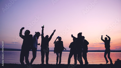 Photography Silhouette of Group young dancing people have a party at beach on sunset