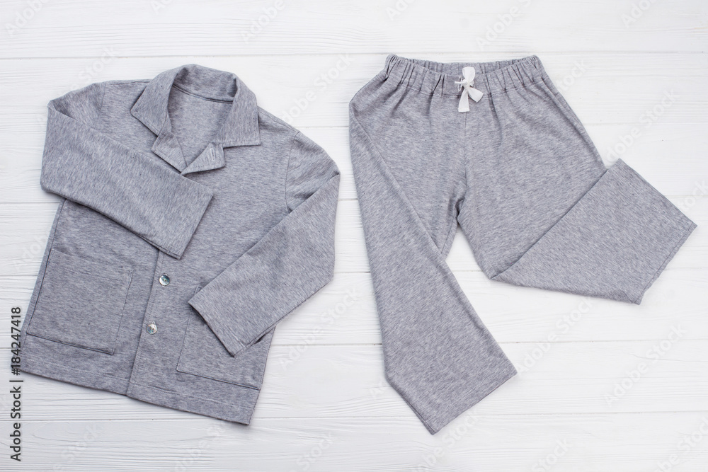 Boys' pajama set on white. Soft gray melange cotton. Loose-fitting shirt and pants for comfort rest at night. - obrazy, fototapety, plakaty 