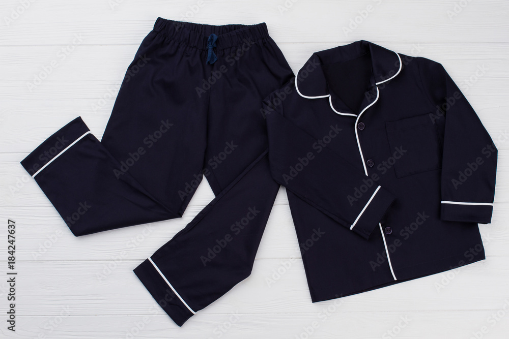 Classic pajama for young boy. Navy shirt and pants decorated with white edging. Simple and elegant. - obrazy, fototapety, plakaty 