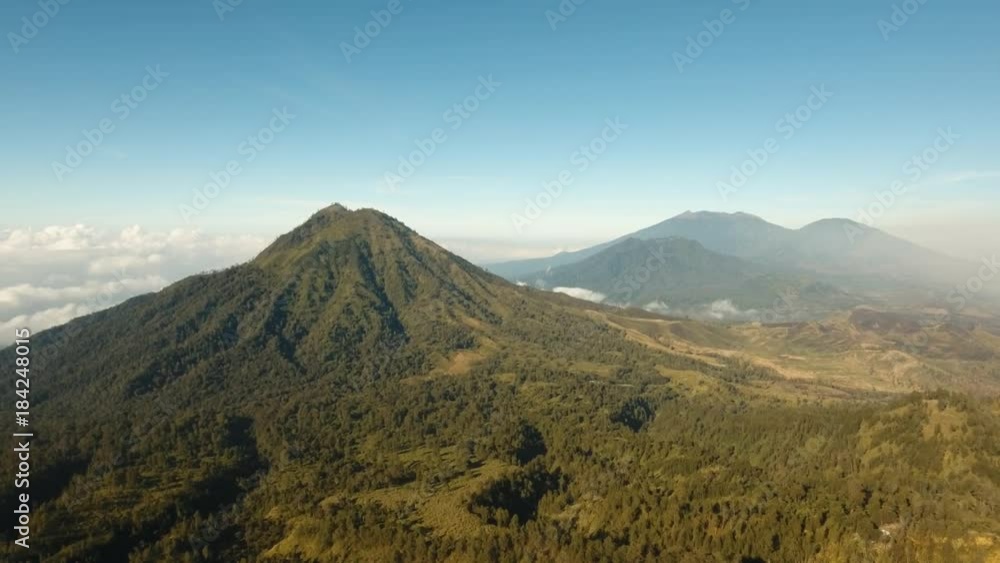 Flight over the mountains in the early morning. Aerial view of Green tropical mountain cover with cloud Banyuwangi Regency of East Java, Indonesia. 4K Aerial footage. Flight over the mountains in the early morning. Aerial view of Green tropical mountain cover with cloud Banyuwangi Regency of East Java, Indonesia. 4K Aerial footage.