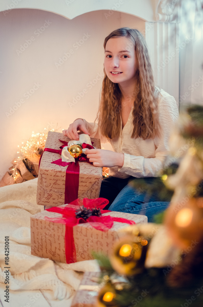 Teenage girl opening the present Teenage girl opening the present