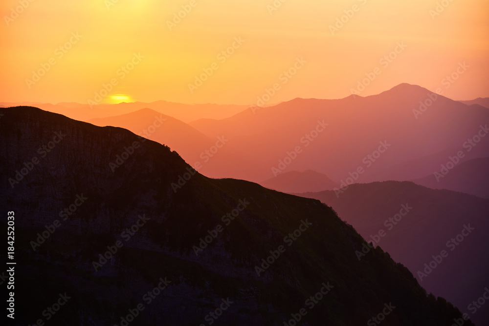 Beautiful sunset or sunrise in mountains in yellow orange and ultraviolet colours