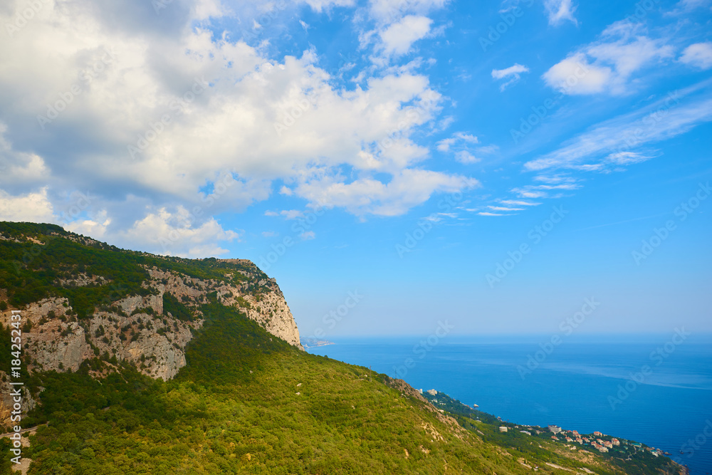 View to the top of the mountain, blue sea and cloudy sky View to the top of the mountain, blue sea and cloudy sky