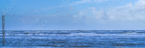 Wind turbines in the North Sea, view from the beach, panorama