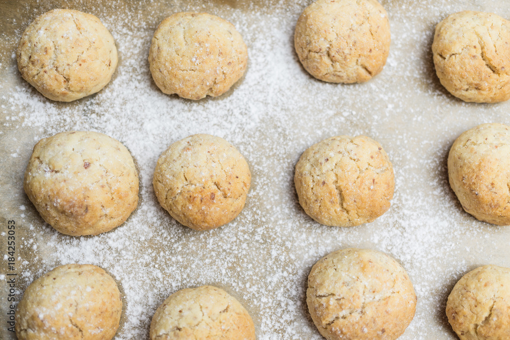 Fresh bakened Christmas nut cookies with icing sugar on baking tray Fresh bakened Christmas nut cookies with icing sugar on baking tray