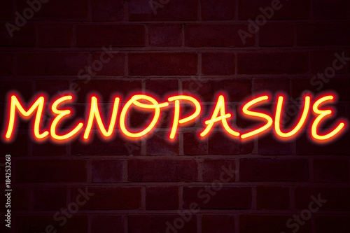 Menopause neon sign on brick wall background. Fluorescent Neon tube Sign on brickwork Business concept for Midlife Crisis Grand Climacteric 3D rendered