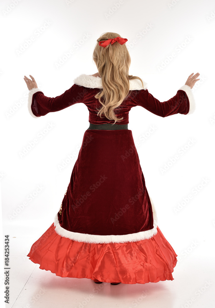 full length portrait of pretty blonde lady wearing red and white christmas inspired costume gown, standing pose on white background. full length portrait of pretty blonde lady wearing red and white christmas inspired costume gown, standing pose on white background.