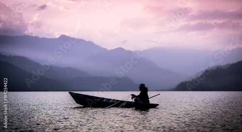 Lonely fisherman on the boat fishing in Phewa lake, Nepal