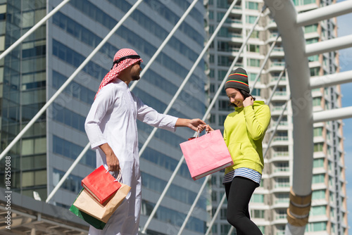 Arabic man and tourist woman shopping in city