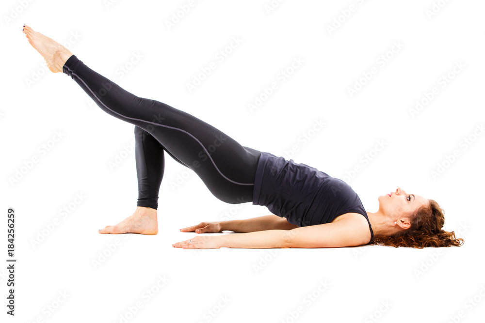 Young fit woman doing pilates excercises isolated on white background
