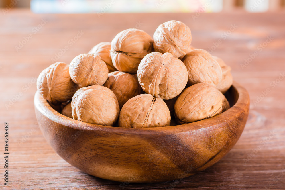 Obraz premium Plate with walnuts on a wooden table