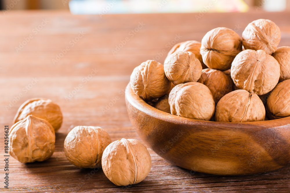 Walnuts in a plate and lie on a wooden table Walnuts in a plate and lie on a wooden table
