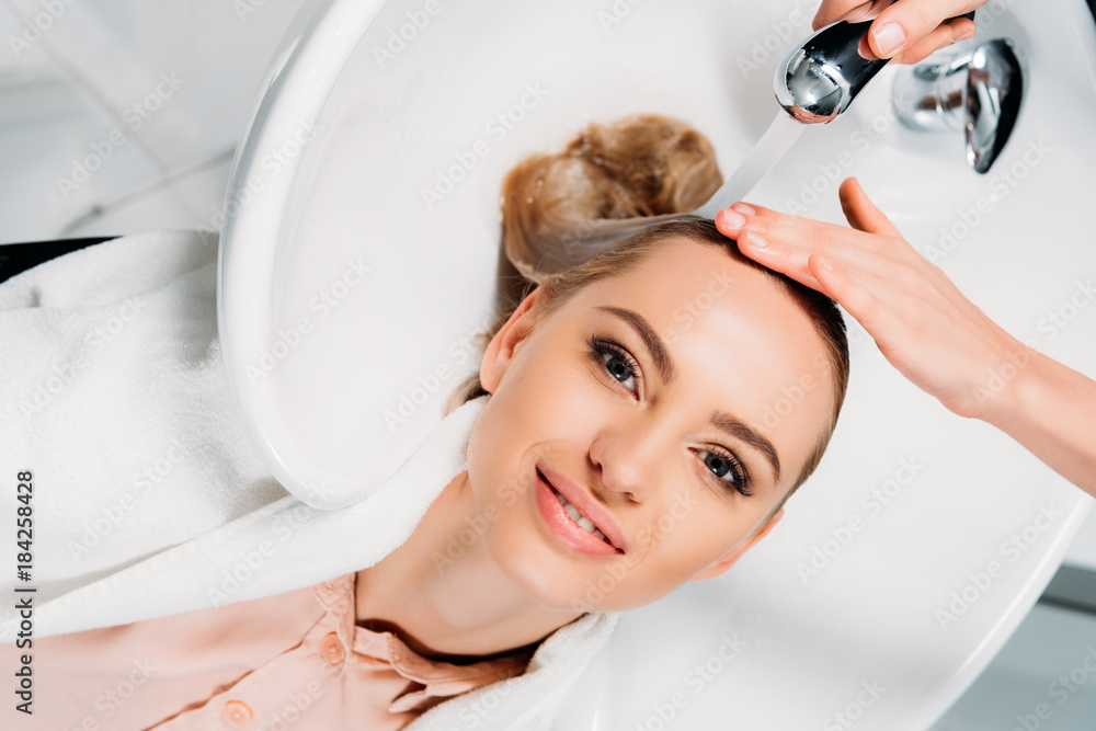 Φωτογραφία top view of hairdresser washing hair for customer at salon