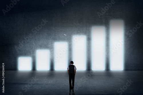 Businessman standing in the front of growth chart of profits