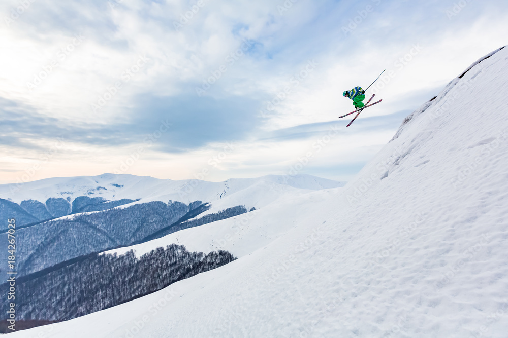 A skier is jumping from the cliff.