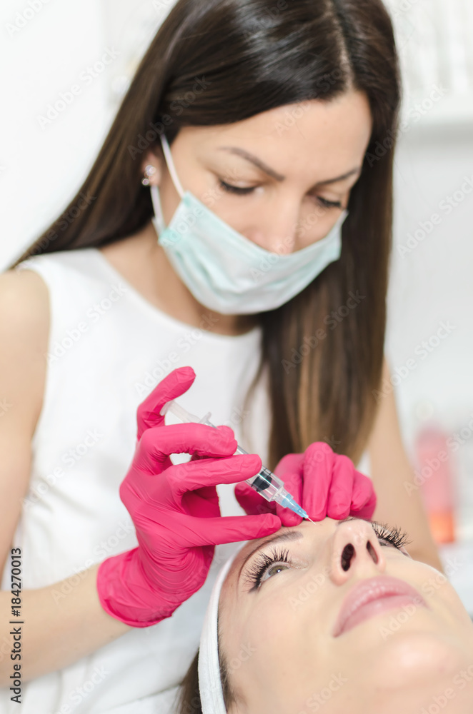 Middle aged woman receiving injection in face