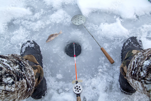 winter fishing, fishing rod stands on the hole waiting for the fish to bite photo