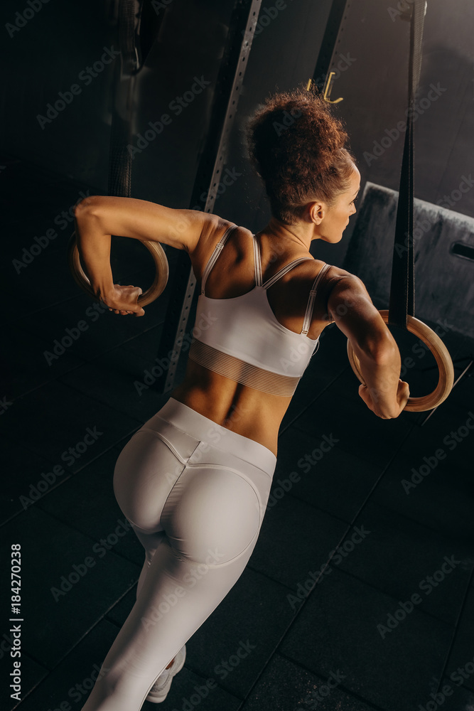 Workout on crossfit rings fitness woman the in gym. Sexy beautiful athletic  ass, female in sport. A young womans body. Gymnastic Stock Photo | Adobe  Stock
