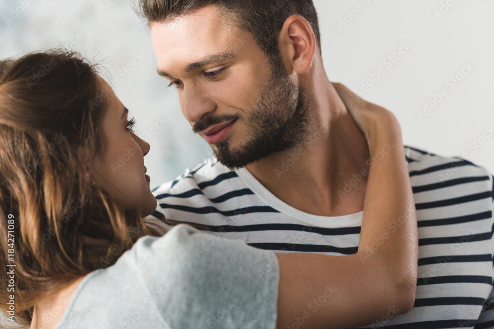 young beautiful couple embracing and looking at each other young beautiful couple embracing and looking at each other