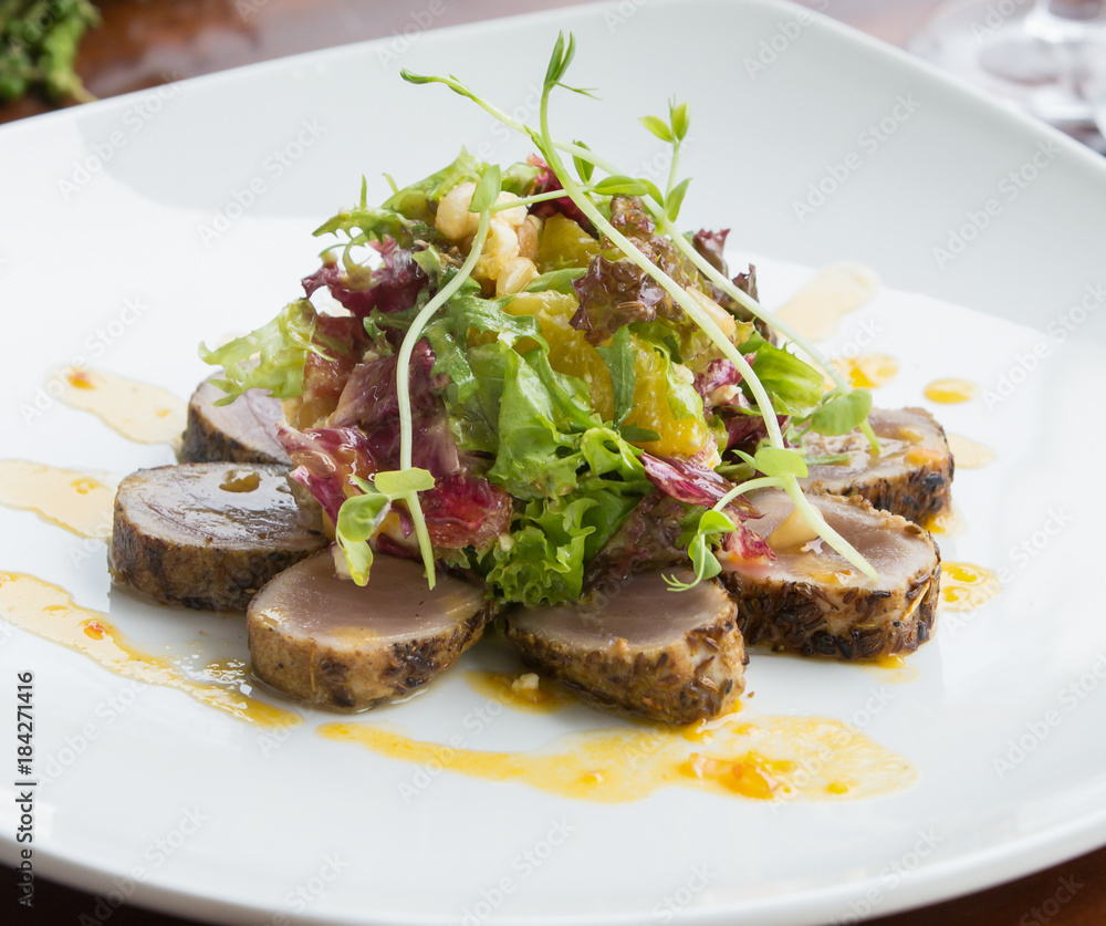 Crusted seared tuna served with vegetables and orange sauce Crusted seared tuna served with vegetables and orange sauce