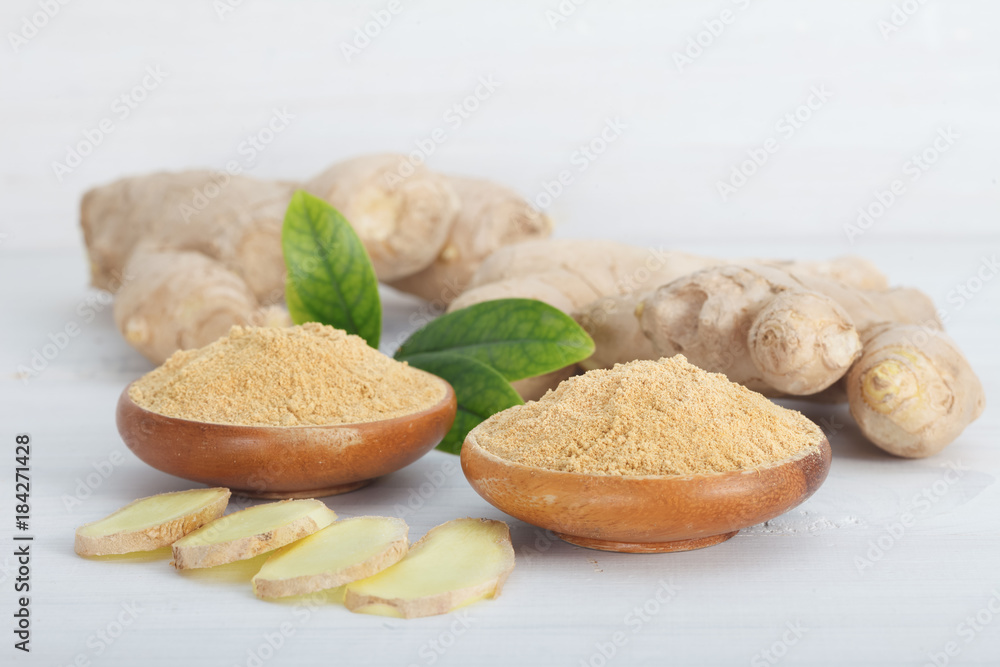 Ginger root and ginger powder in the bowl Ginger root and ginger powder in the bowl