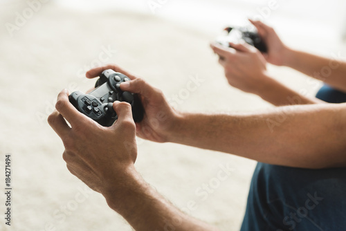 cropped shot of couple playing computer games with gamepads