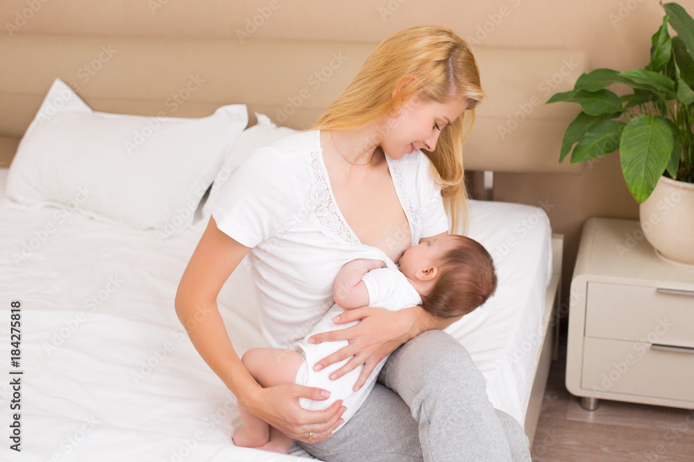 mother breast feeding and hugging her baby. Mom breastfeeding her baby boy in a light room at home. Mother feeding breast her daughter at domestic bedroom mother breast feeding and hugging her baby. Mom breastfeeding her baby boy in a light room at home. Mother feeding breast her daughter at domestic bedroom