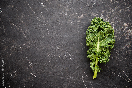 Fresh superfood kale on dark wooden background. The concept of healthy diet 