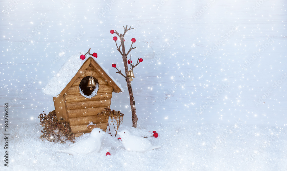 Christmas winter background with birdhouse and birds pecking berries on snow Christmas winter background with birdhouse and birds pecking berries on snow