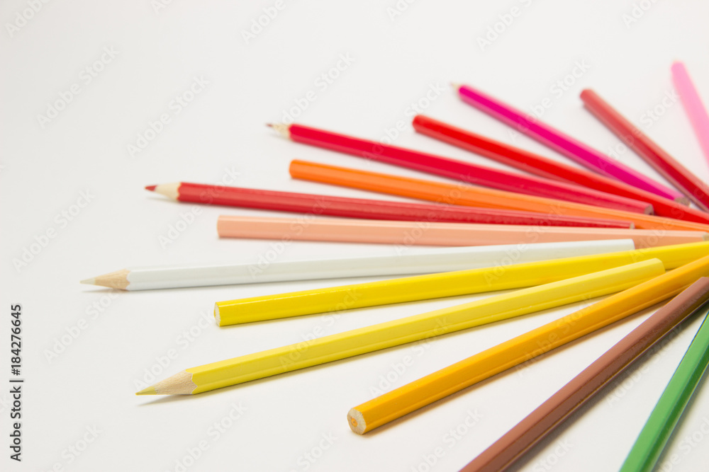 A group of pencils folded in rainbow colors in a circle on a white background A group of pencils folded in rainbow colors in a circle on a white background