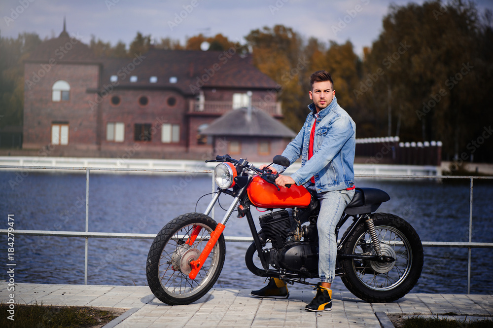 young sports fashionable man on a motorcycle, a warm shot, late autumn