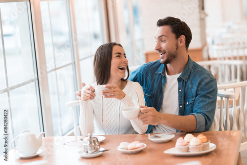 A guy and a girl are sitting together in a cafe.