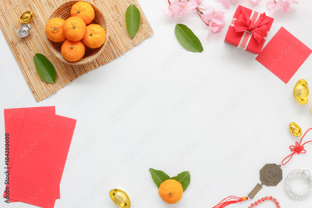 Top view shot of arrangement decoration Chinese new year & lunar festival concept background.Orange & tea pot also red pocket money with map to travel.Variety object on modern brown wood at home desk. Top view shot of arrangement decoration Chinese new year & lunar festival concept background.Orange & tea pot also red pocket money with map to travel.Variety object on modern brown wood at home desk.