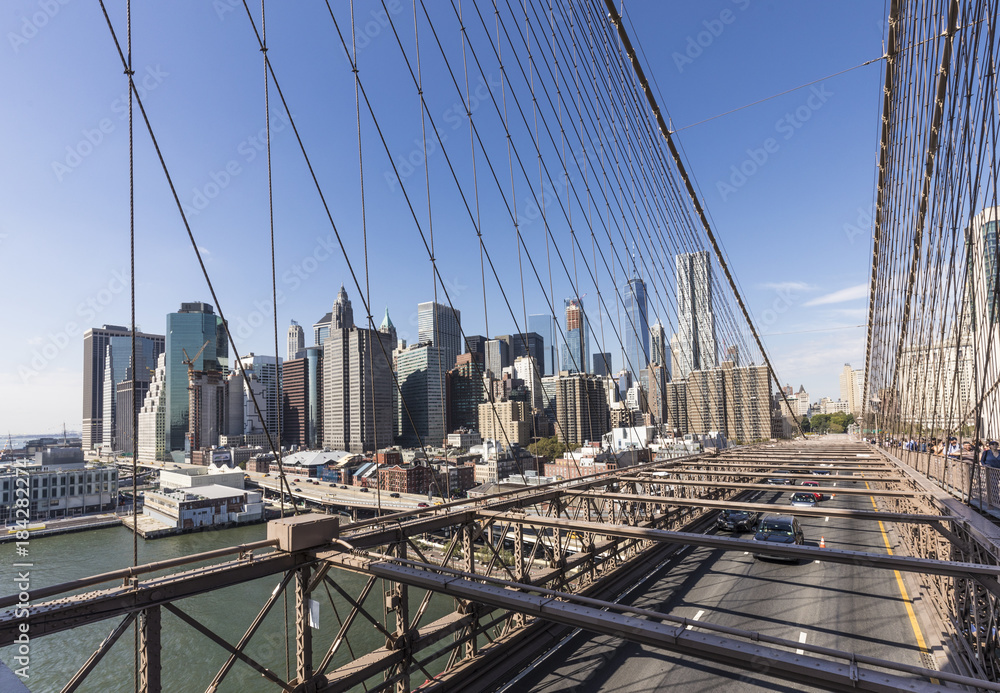 Fototapeta premium people cross famous Brooklyn Bridge in New York