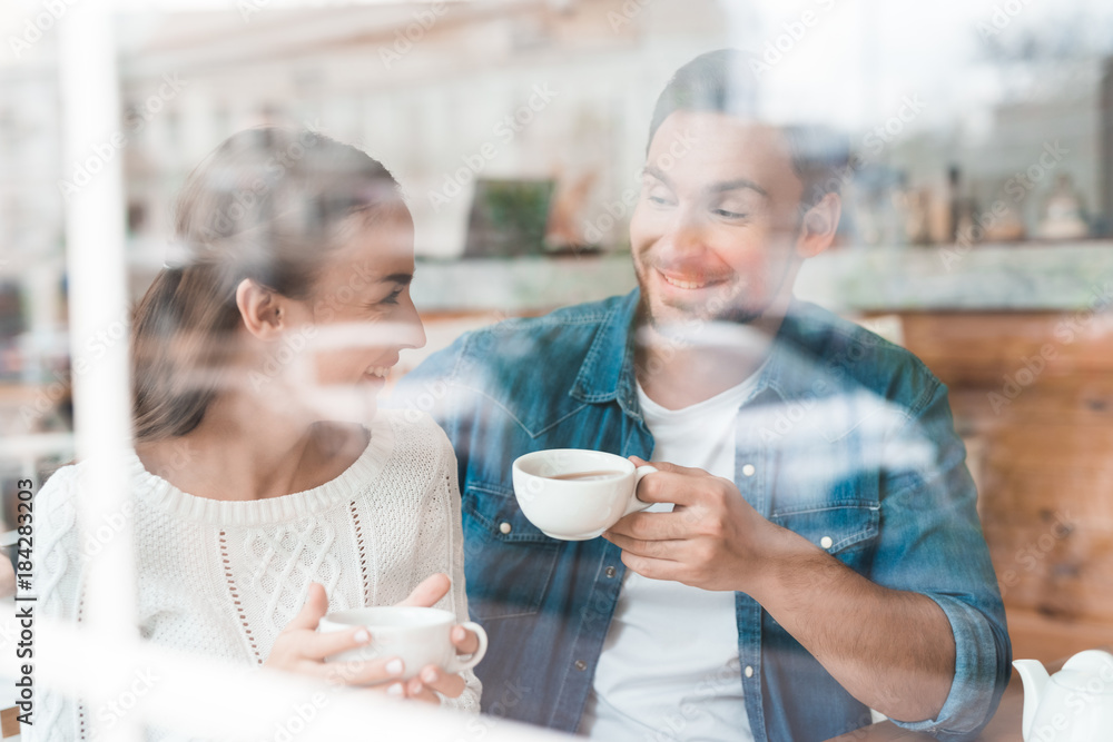 A guy and a girl are sitting together in a cafe. A guy and a girl are sitting together in a cafe.