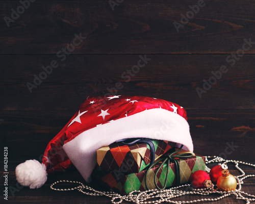 Closeup New Year's fir-tree toy and festive boxes in colourful paper on a wooden background. Holidays gift background. Christmas gifts. photo