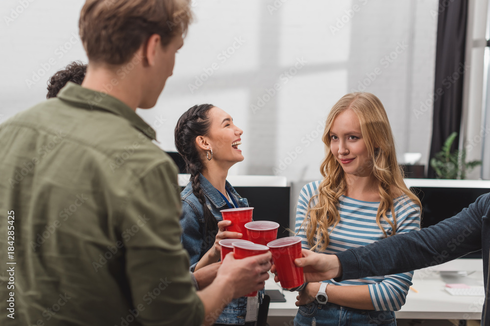 young attractive people clinking cups at modern office young attractive people clinking cups at modern office