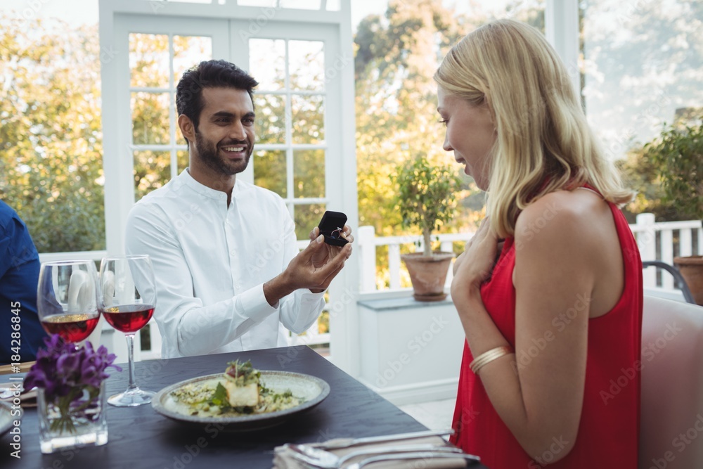 Man proposing woman while having meal