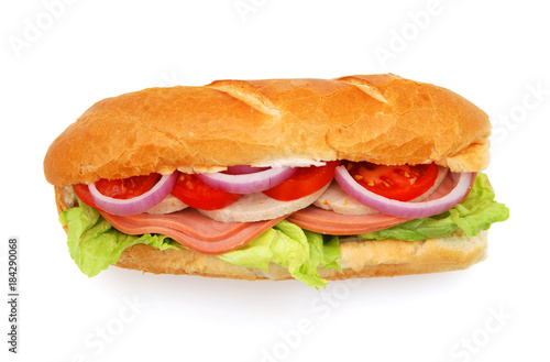 Long sandwich with ham, cheese, tomatoes, red onion and lettuce. Isolated on white