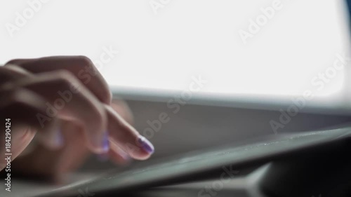 Young girl typing and working with the tablet. Close-up of hands with manicure.