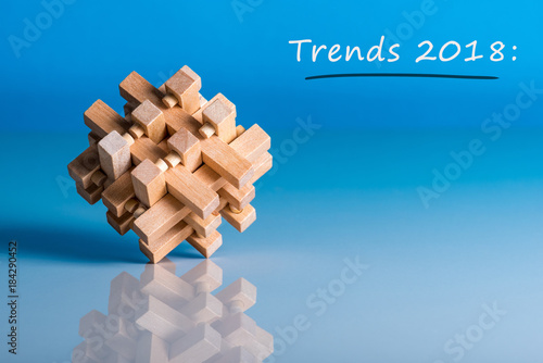 TRENDS 2018. New trend at business innovation technology and other areas. Blue background with macro view of brain teaser and empty space for text, Mockup photo