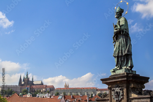 Sculpture on Charles Bridge with the cityscape of Prague on the background