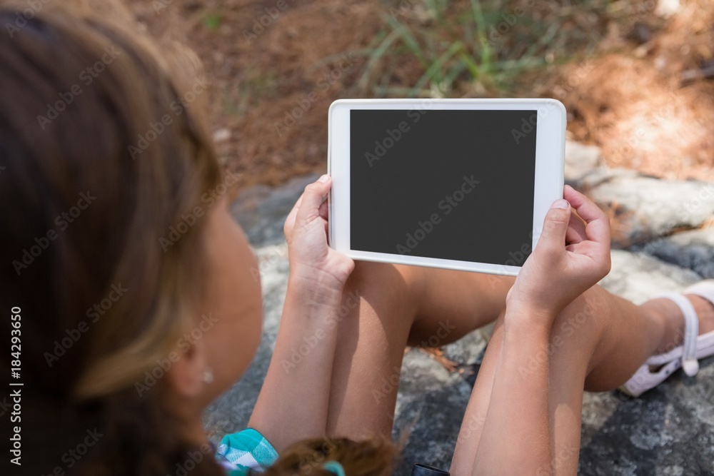 Girl holding digital tablet in the forest