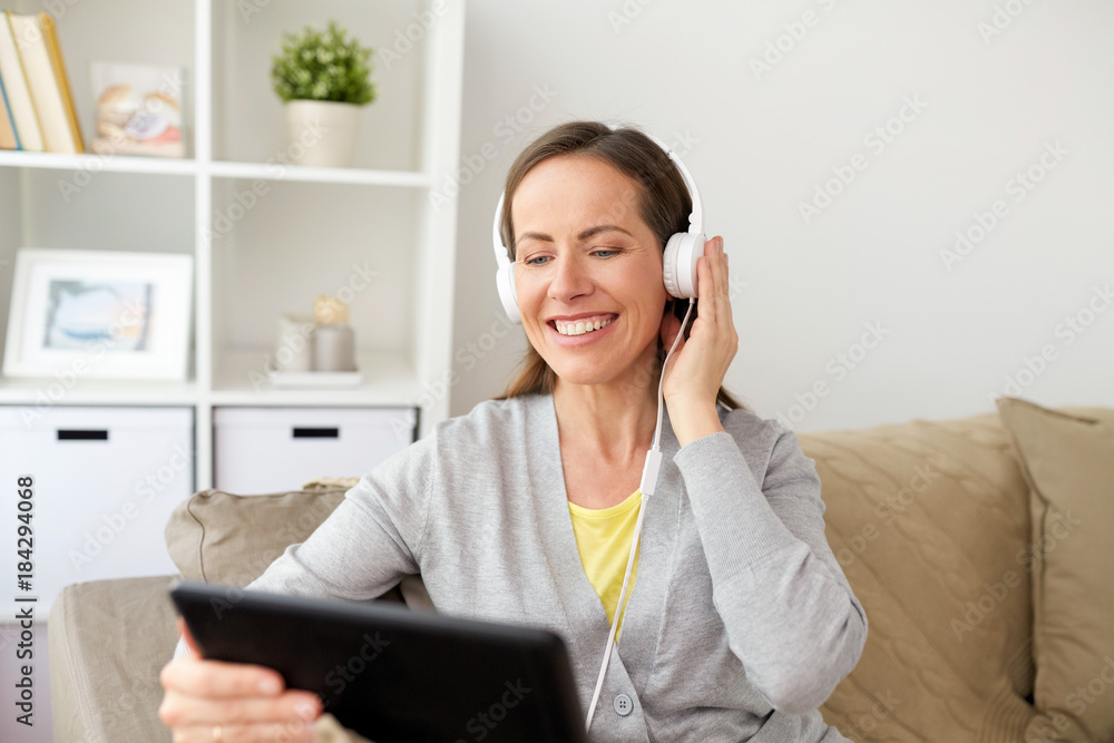 happy woman with tablet pc and headphones at home happy woman with tablet pc and headphones at home