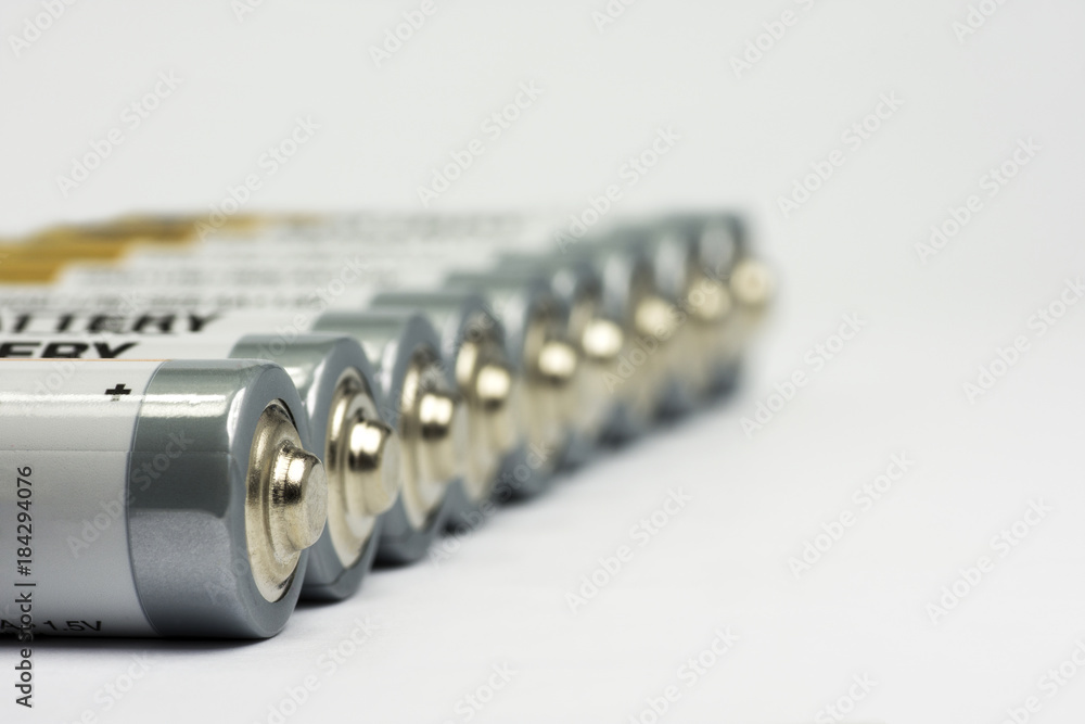 Row lying AA battery on white background with blurred background Row lying AA battery on white background with blurred background