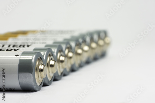 Row lying AA battery on white background with blurred background