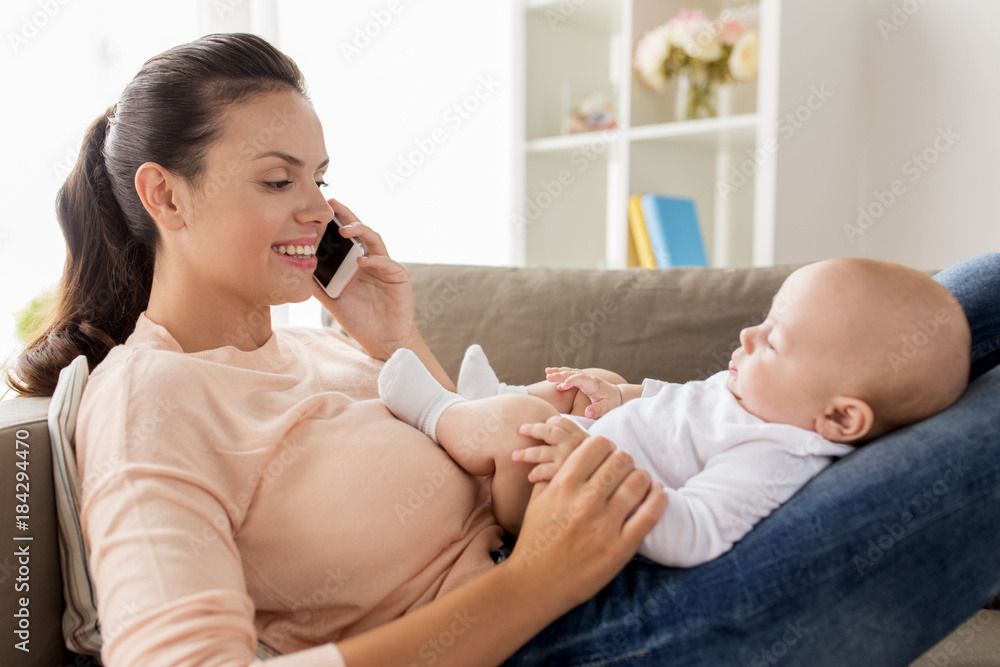 mother with baby calling on smartphone at home mother with baby calling on smartphone at home